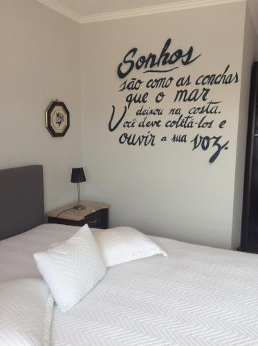 a bedroom with a bed with a sign on the wall at Guest House A&z in Espinho