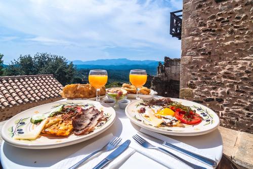 two plates of food on a table with glasses of orange juice at Petropoulakis Tower in Gythio