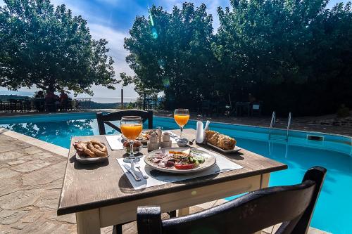 a table with food and drinks next to a pool at Petropoulakis Tower in Gythio