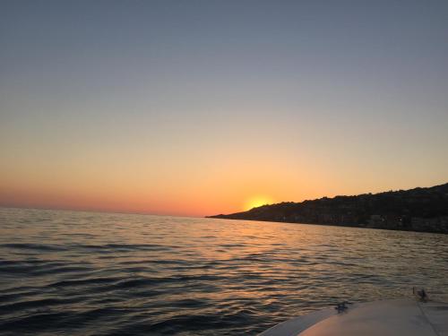 a sunset from the back of a boat in the water at La Collina sul Mare in Palma di Montechiaro