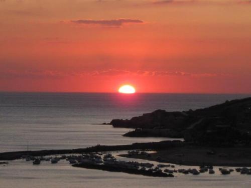 a sunset over the ocean with the sun in the sky at La Collina sul Mare in Palma di Montechiaro