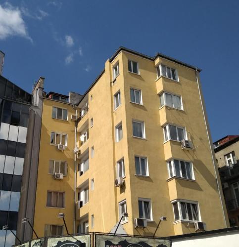 un edificio giallo con finestre su una strada di Sunshine Sofia a Sofia