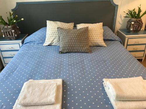 a blue bed with polka dot sheets and pillows at RighePois in Reggio Calabria