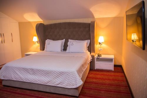 een slaapkamer met een groot bed met witte lakens en kussens bij Santa Quaranta Premium Resort in Sarandë