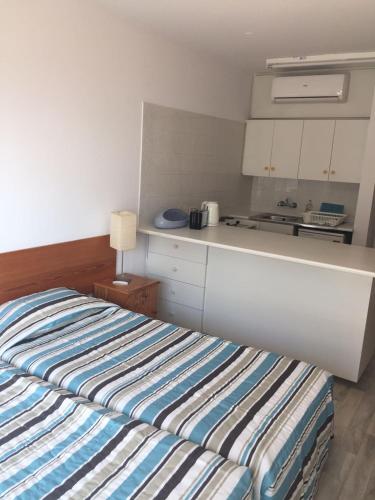 a bedroom with a bed and a kitchen in it at Nautilus Tourist Apartments in Larnaka
