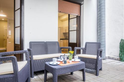 a group of wicker chairs and a table on a patio at Apartamento Urumea in Donostia-San Sebastián