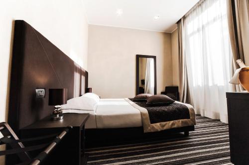 a hotel room with a bed and a large window at Hotel Principe Di Torino in Turin