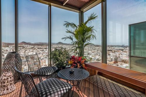 a balcony with a table and chairs and a view of a city at Arrecife Gran Hotel & Spa in Arrecife