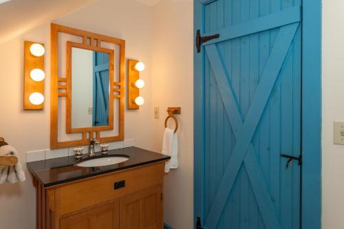 La salle de bains est pourvue d'une porte bleue et d'un lavabo. dans l'établissement Inn at Buck Hollow Farm, à Fairfax