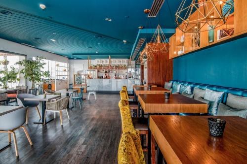 a restaurant with blue ceilings and wooden tables and chairs at Arrecife Gran Hotel & Spa in Arrecife