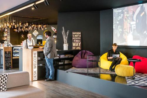 a group of people standing at a counter in a bar at Novotel Lille Centre Gares in Lille