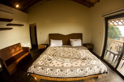 a bedroom with a bed and a balcony at Paradise Project Hostal in Montañita