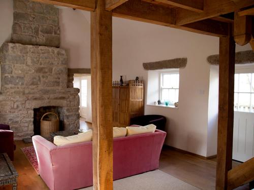 a living room with two pink couches and a stone fireplace at Kilgraney House in Bagenalstown