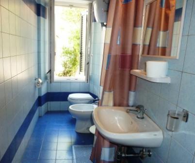 a bathroom with a toilet and a sink and a window at Hotel Bolognese in Foligno