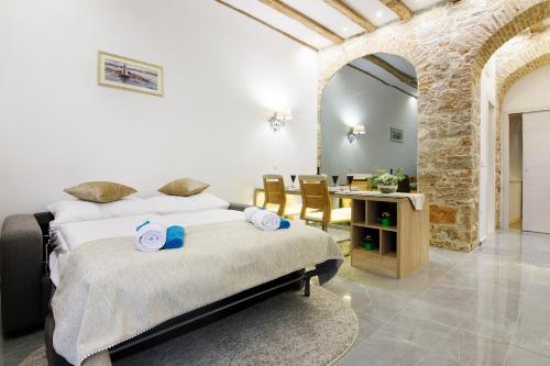 1 dormitorio con 1 cama y 1 mesa con sillas en Dalti Center Apartment, en Zadar