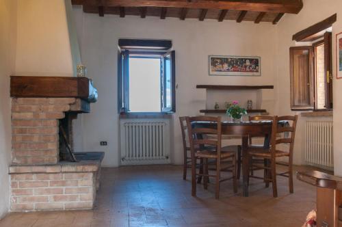 a dining room with a table and a fireplace at Corte Fratini Appartamenti in Trevi