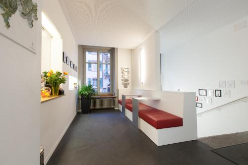 une chambre avec un comptoir avec un banc rouge dans l'établissement Hotel Alpha, à Lucerne