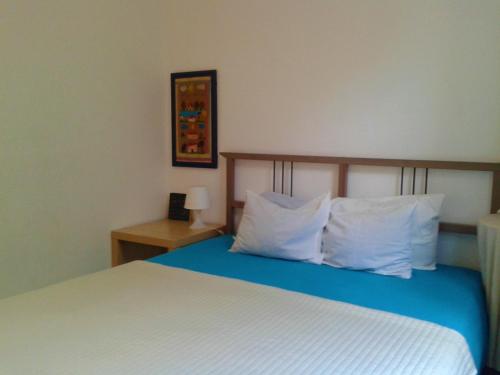 a bedroom with a bed with white sheets and pillows at Casas Botelho Elias in Pinhão