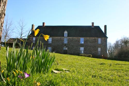 una gran casa de ladrillo con flores delante en Le Manoir de Herouville, en Litteau