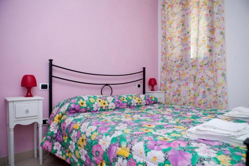 a bedroom with a bed with a floral bedspread at Lavanda e Rosmarino Home in Assisi