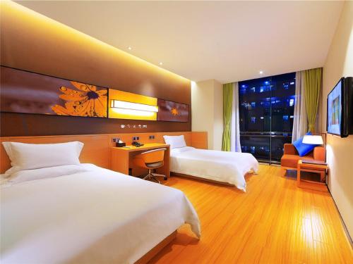 a hotel room with two beds and a desk at IU Hotel Suzhou Mudu Old Town Kaima Square in Suzhou