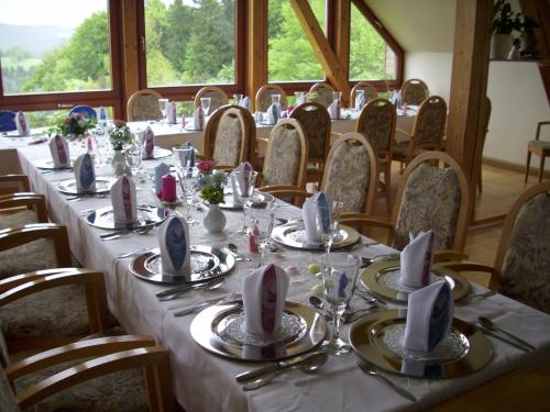 una mesa larga con platos y servilletas en la parte superior en Hotel & Restaurant Danelchristelgut, en Lauter