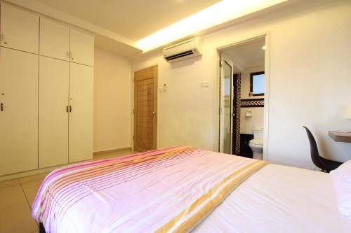 a white bedroom with a bed and a bathroom at Vista Horizon Melaka in Melaka