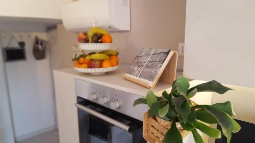 a kitchen with a bowl of fruit on top of an oven at Fly Windows Apartment in Ciampino