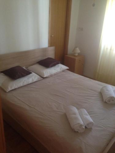 a white bed with two towels on top of it at Apartman Roko in Tribunj