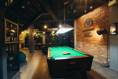 a room with a pool table and a brick wall at Srisuksant Square in Krabi town
