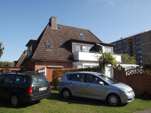 two cars parked in front of a house at Apartment Boje in Büsum