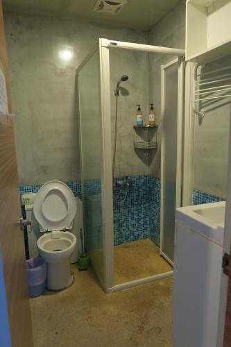 a bathroom with a shower and a toilet and a sink at Being Outdoor in Gongliao