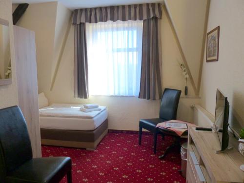 Un pat sau paturi într-o cameră la Hotel Friedchen mit eigener Fleischerei