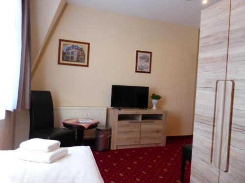 a hotel room with a bed and a television at Hotel Friedchen mit eigener Fleischerei in Artern