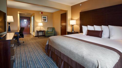a hotel room with a large bed and a desk at Wingate by Wyndham Harrisburg Near Hershey in Harrisburg