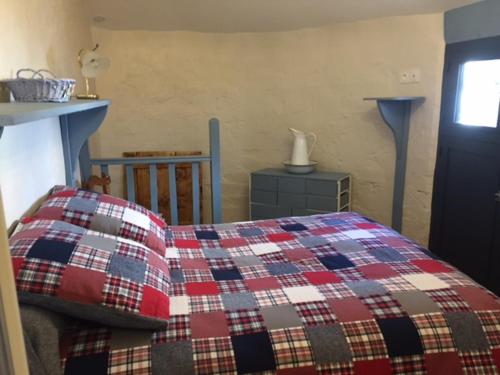 DourgneにあるLe Pastel de l'Autanのベッドルーム1室(チェック入りの毛布付きのベッド1台付)