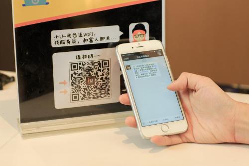 a person holding a cell phone in front of a microwave at IU Hotel Chizhou Xiushanmen in Chizhou