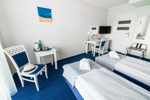 a hotel room with two beds and a table and chairs at Portobello in Ustka