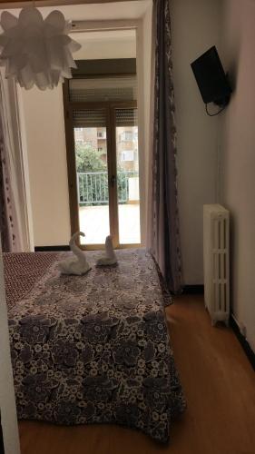 a bedroom with a bed and a large window at Hostal Lima in Valladolid