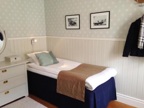 a small bedroom with a bed and a dresser at Kivikstrand Badhotell in Kivik