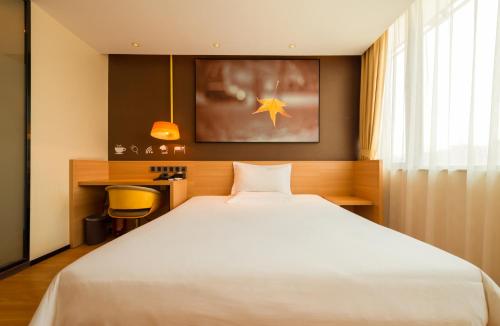 a bedroom with a large white bed and a desk at IU Hotel Norh Guiyang Century City Convention Center in Guiyang