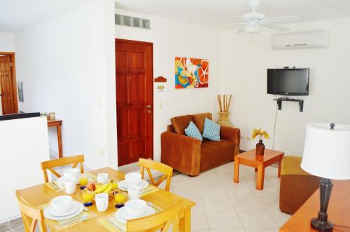 a living room with a table and a couch at Corales Suites in Puerto Morelos