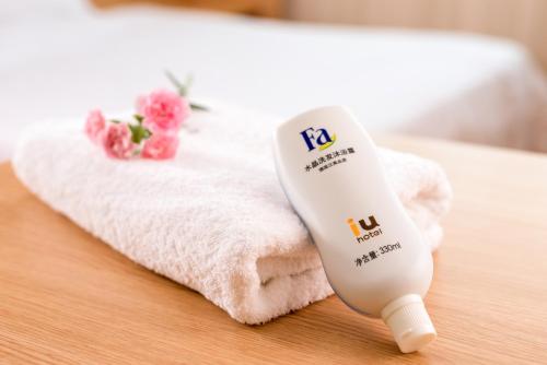 a white electric hair dryer on a table next to a towel at IU Hotel Luoyang Yanshi White Horse Temple in Shouyangshanzhen