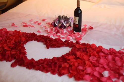 a heart shaped cake with a bottle of wine and wine glasses at IU Hotel Luoyang Yanshi White Horse Temple in Shouyangshanzhen