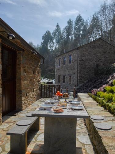 a table with plates and bowls on a patio at Aldea Rural y Gastro Restaurante Casona de Labrada in Labrada