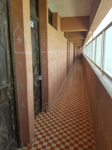 an empty hallway with a checkered floor and doors at Residence Tafat in Agadir