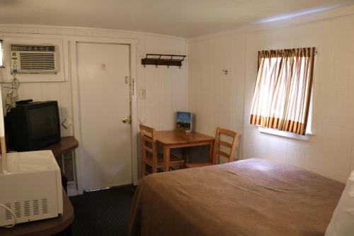 a hotel room with a bed and a table and a television at Red Caboose Motel & Restaurant in Ronks