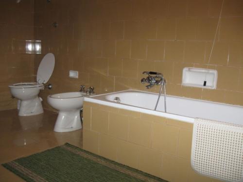 a bathroom with a toilet and a bath tub and a toilet and a sink at Albergo Ristorante Guidi in Pistoia