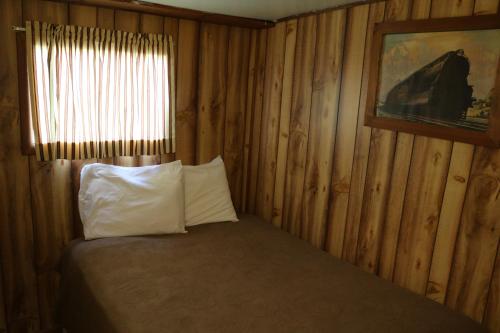 a bedroom with a bed with a window and a pillow at Red Caboose Motel & Restaurant in Ronks