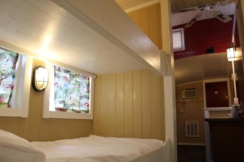 a small room with a bed and two windows at Red Caboose Motel & Restaurant in Ronks